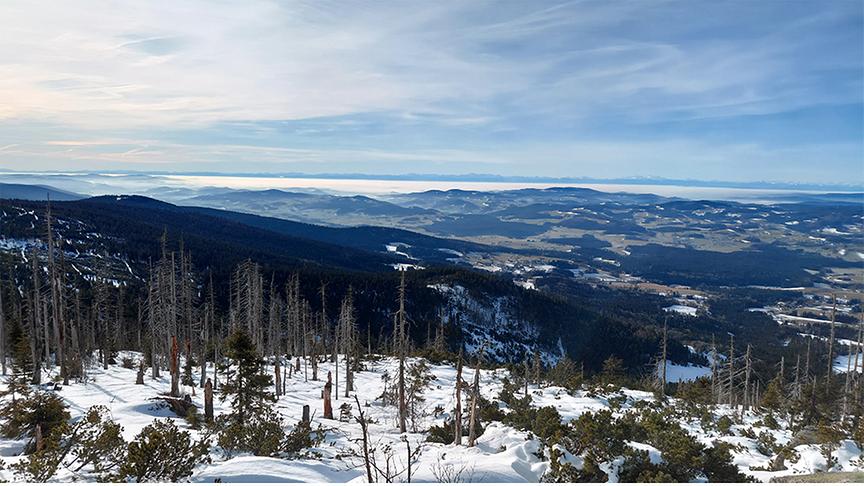 Auf dem Berg liegt noch Schnee, während im Tal schon alles grün ist