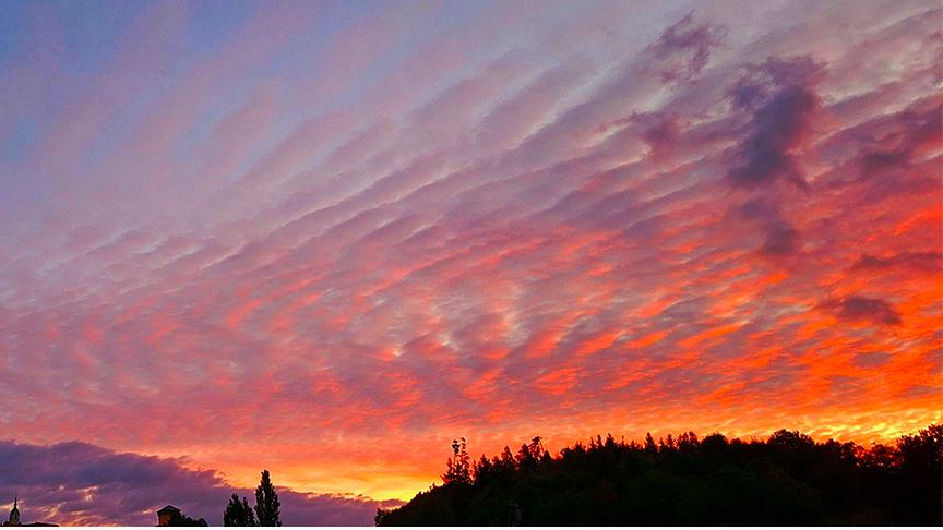 Abenddämmerung, die die wellige Wolkendecke rötlich färbt