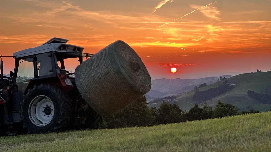 © Karin Schauppenlehner Abendstimmung Sonnenuntergang am Freithofberg, Grenze Nö-Oö (Mostviertel-Traunviertel) Heuballen einfahren bevor die Nacht hereinbricht. (Karin Schauppenlehner)