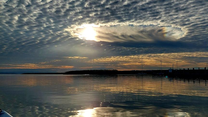 Schäfchenwolken mit Wolkenloch über dem Neusiedler See