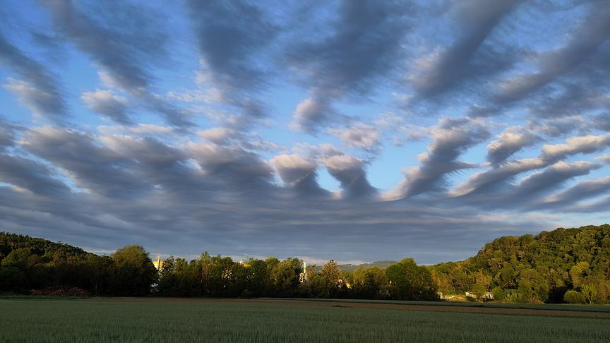 Ungewöhliche Wolkenformationen mit mehreren parallelen Wolkenstreifen. 