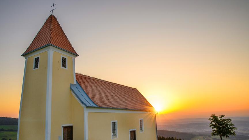© Magret Bernschütz Sonnenaufgang am Pongrazer Kogel im Bild Kirche Sankt Pangrazen (Magret Bernschütz)