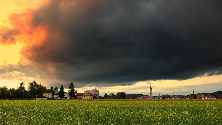 © REINHARD WEIGEL DUNKLE WOLKEN ÜBER DER KIRCHE: ES BRAUT SICH HEUTE WAS ZUSAMMEN ÜBER DER KIRCHE ST.STEPHAN HINTER DEM SENFKRAUTFELD IN BRAUNAU AM INN. (REINHARD WEIGEL)